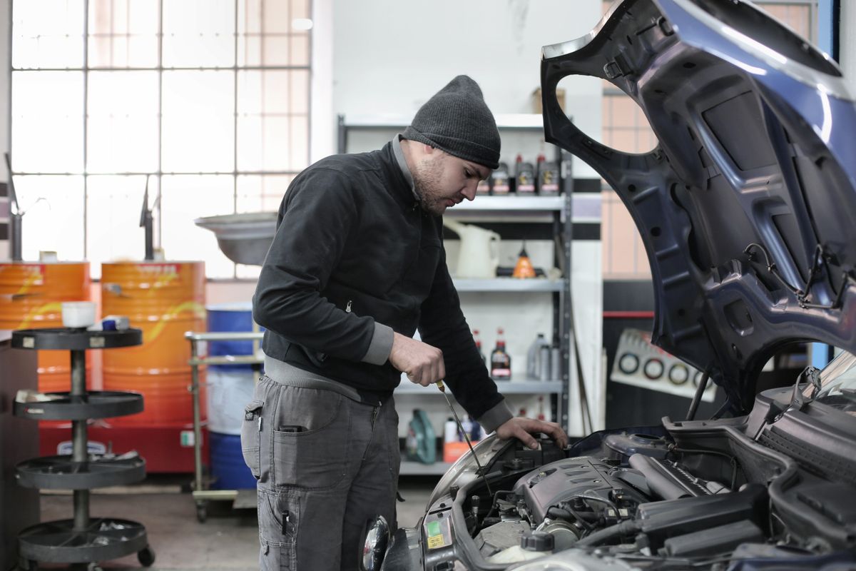 Technician working on a vehicle engine in a workshop
